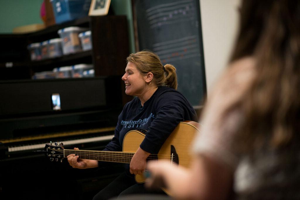 Student playing guitar in class